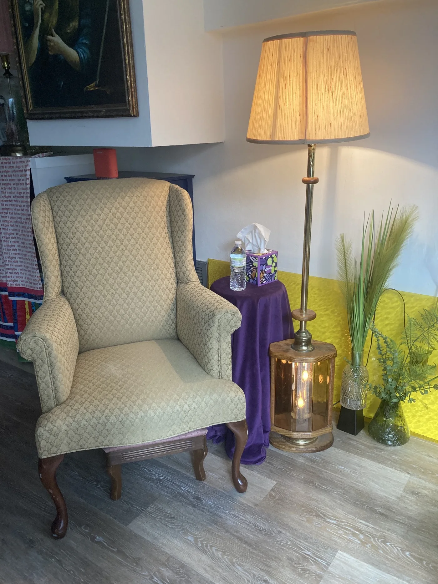 Quiet seating area inside the Ramaste studio with a lamp, chair, and plants